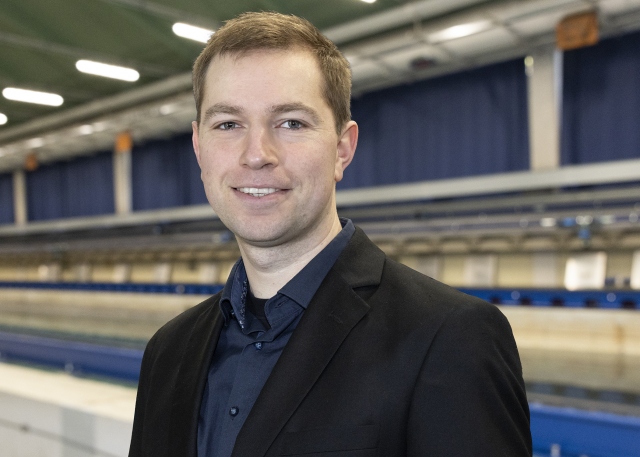 David Frank steht vor dem Schleppkanal in der Strömungshalle.