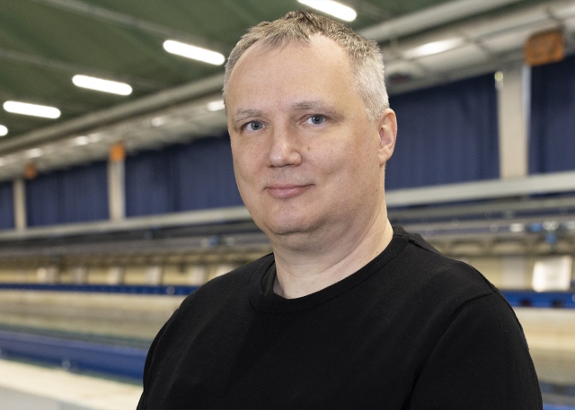 Frank Hüttmann steht vor dem Schleppkanal in der Strömungshalle.