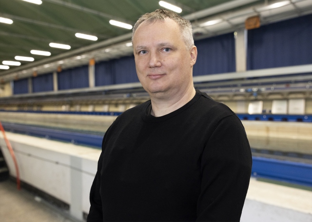 Frank Hüttmann steht vor dem Schleppkanal in der Strömungshalle.