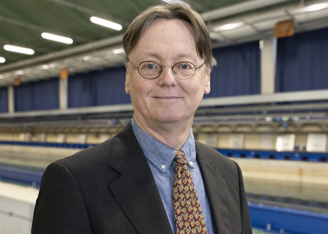 Martin Brede steht vor dem Schleppkanal in der Strömungshalle.