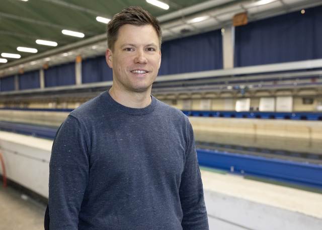 Martin Bruschewski steht vor dem Schleppkanal in der Strömungshalle.