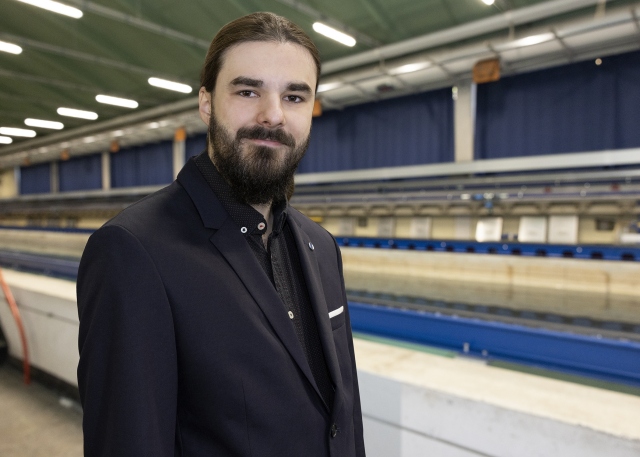 Tobias Bestier steht vor dem Schleppkanal in der Strömungshalle.