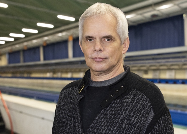 Ulf Grebin steht vor dem Schleppkanal in der Strömungshalle.