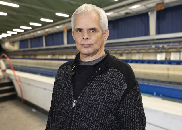 Ulf Grebin steht vor dem Schleppkanal in der Strömungshalle.