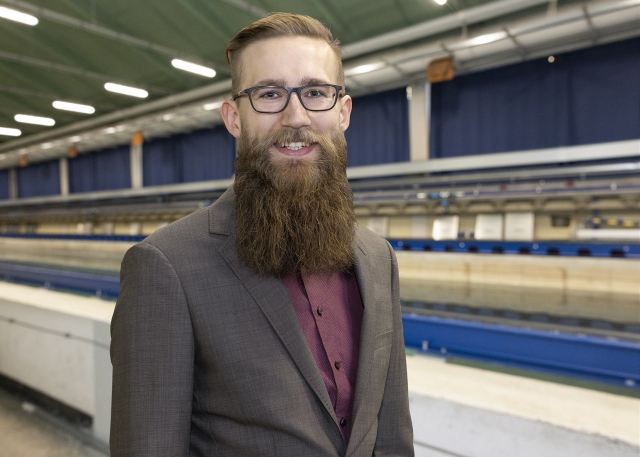 Vincent Klempau steht vor dem Schleppkanal in der Strömungshalle.