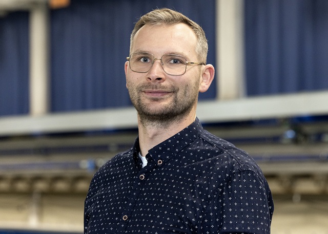 Alex Bluhm steht vor dem Schleppkanal in der Strömungshalle.
