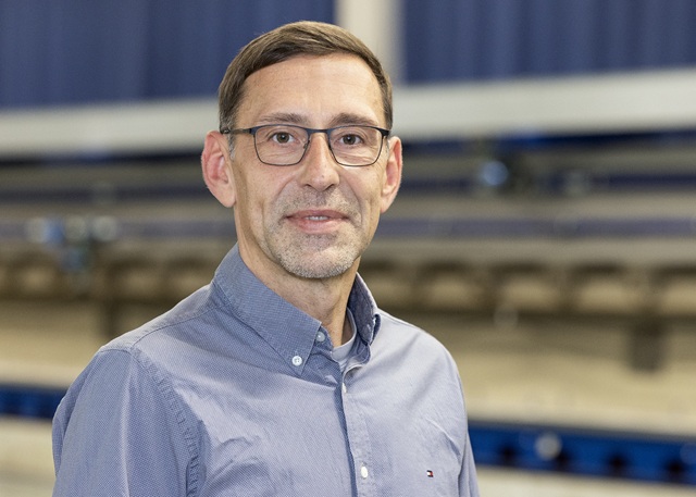 Enrico Skaliks steht vor dem Schleppkanal in der Strömungshalle.